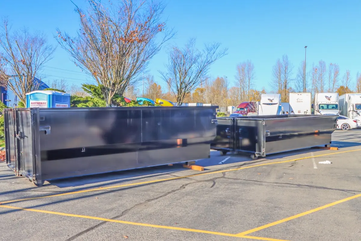 Professional dumpster rental service with roll-off container on residential driveway in Cliffside Park